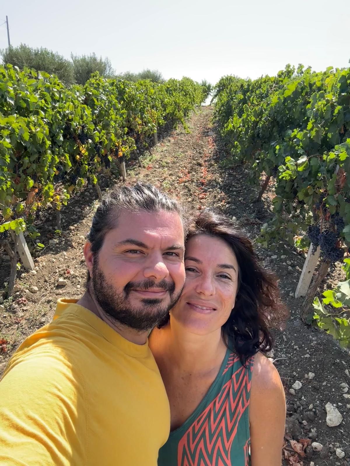 Michael Azzopardi and Ambra Anselmo, the founders of Quiete, smiling together between rows of vines